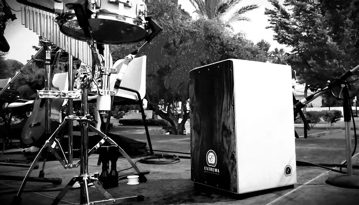 Cajón flamenco sobre un escenario junto a otros instrumentos musicales